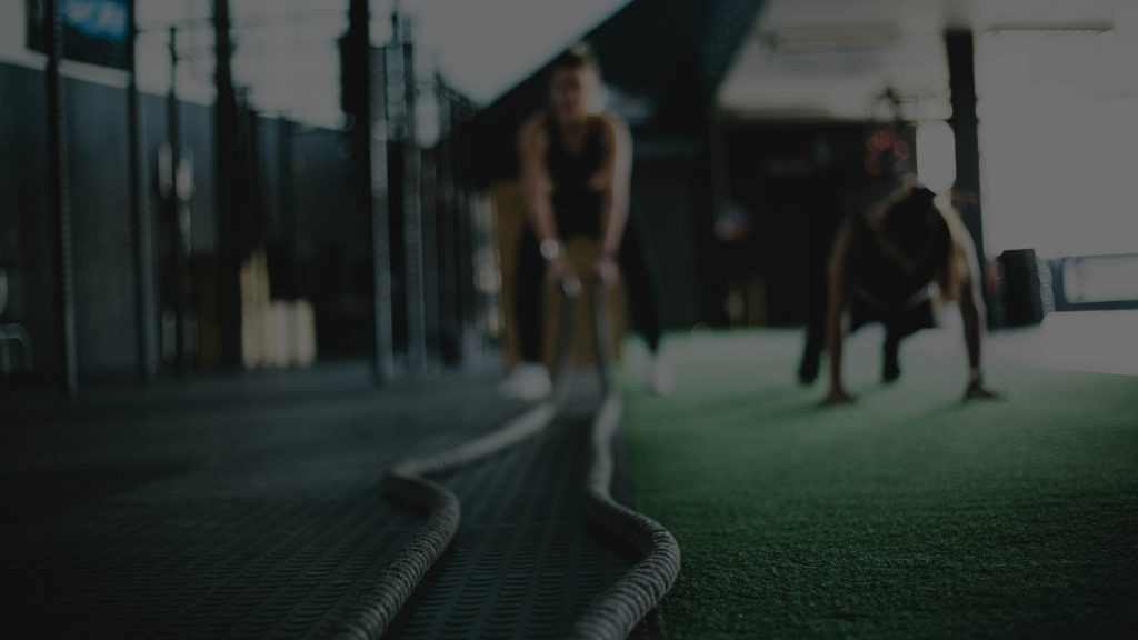 Person som tränar med battle ropes på gym – intensiv styrketräning och funktionell fitness.